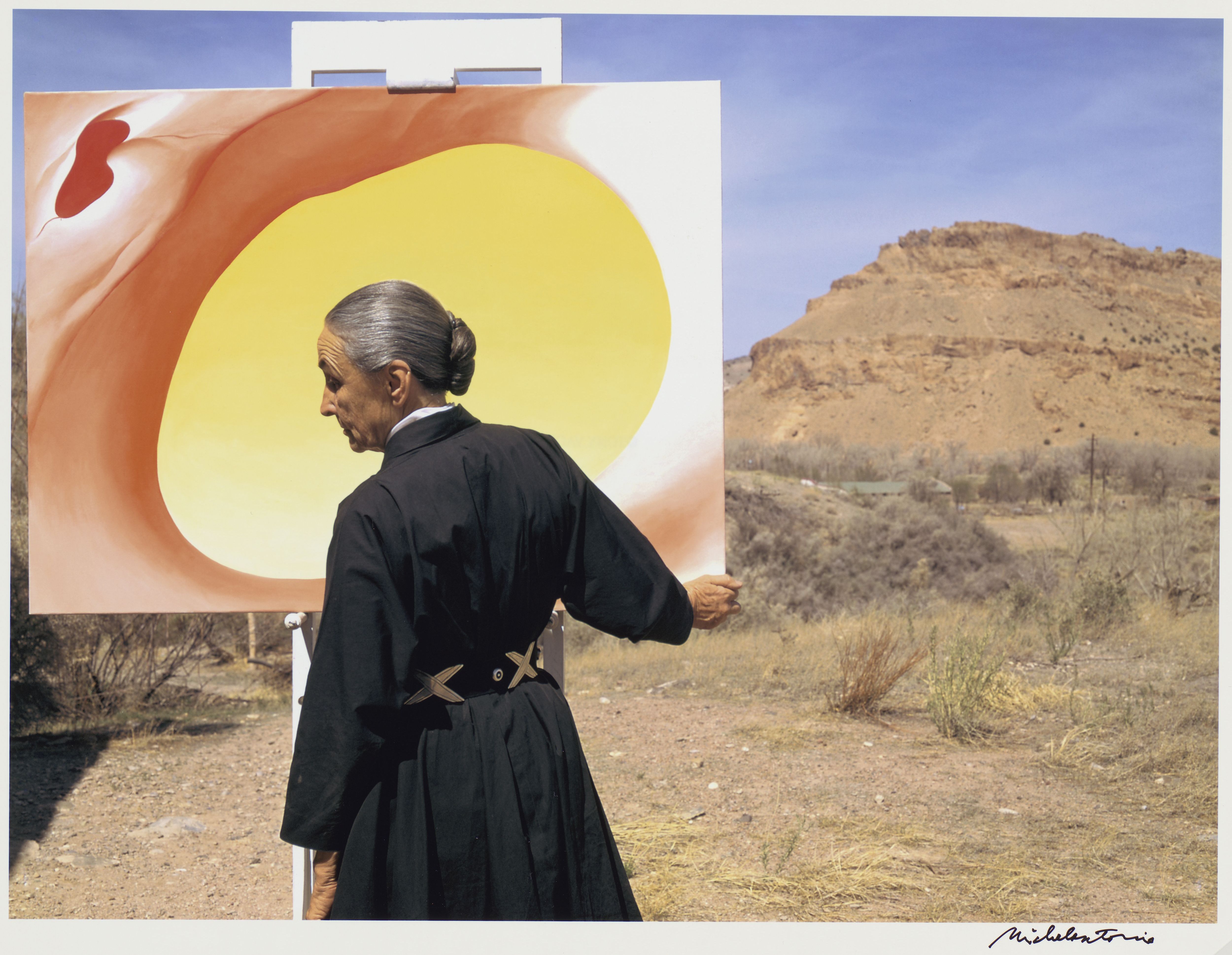 Georgia O'Keeffe with "Pelvis Series, Red with Yellow" and the desert. 1960. Photo: Tony Vaccaro. Source: Georgia O'Keeffe Museum