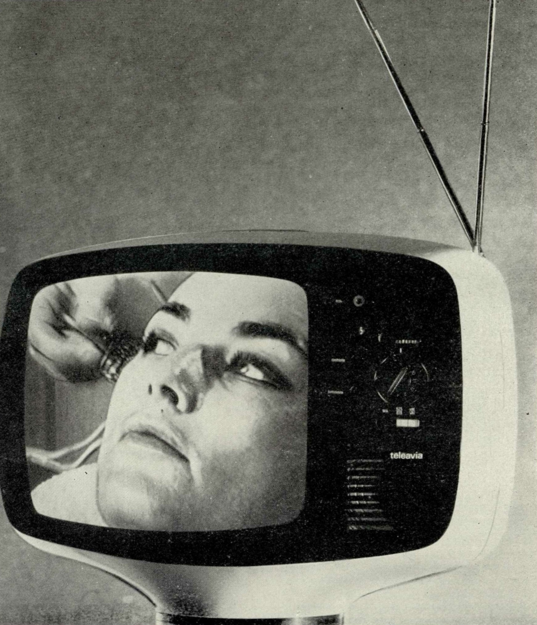 4. Переносный транзисторный телевизор Таллона во время работы. Светлый силуэт экрана четко вырисовывается на черной поверхности фильтра, делающего невидимой катодную трубку кинескопа.