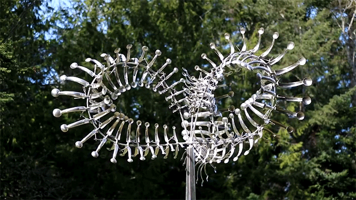 Кинетическая скульптура KweeBe. © Anthony Howe, 2013. Нержавеющая сталь. 4,8 м в высоту × 3 м в ширину × 3 м в глубину. 300 кг. 75 соединённых лопастей, вращающихся на трёх валах