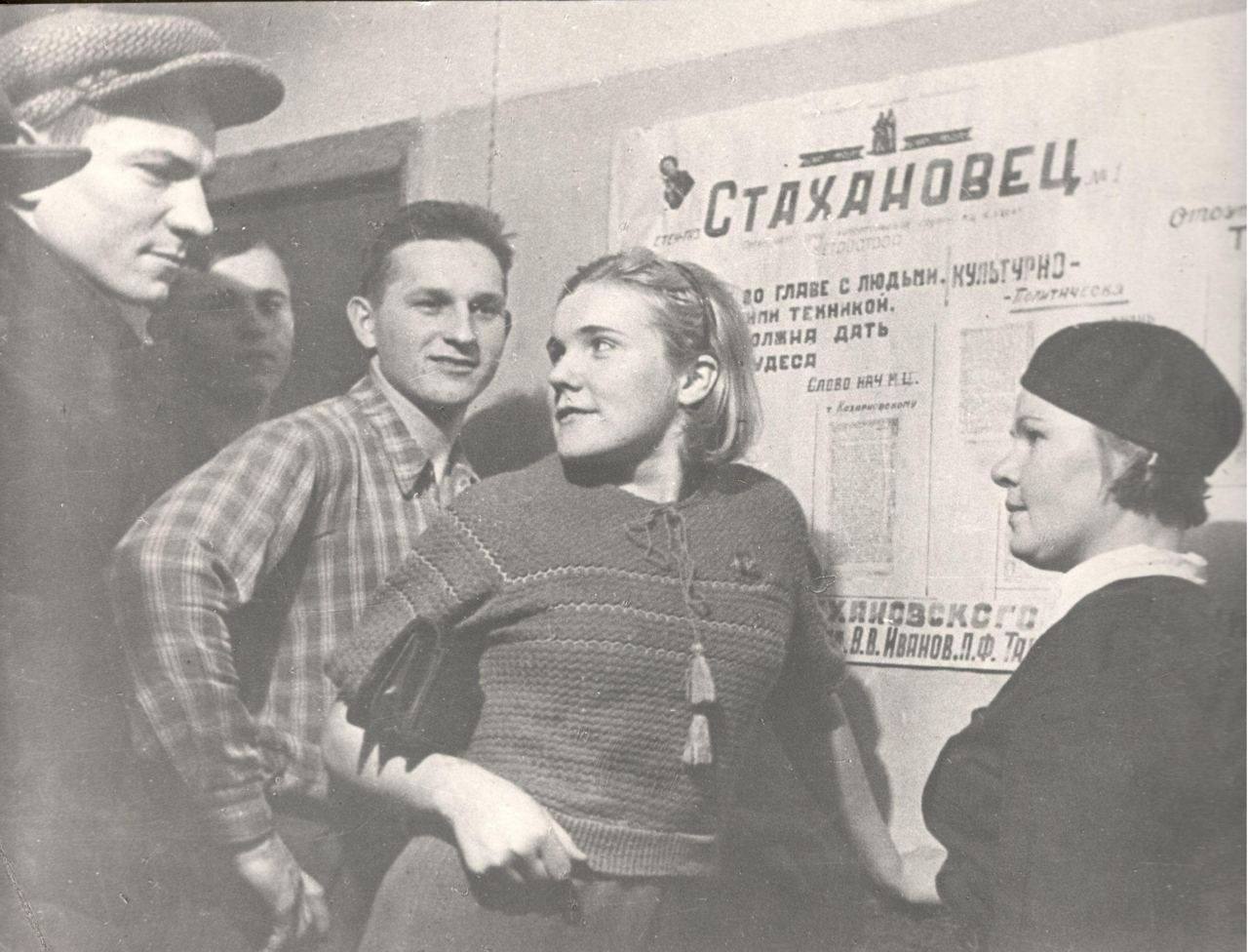 Фото групповое, в центре Киеня С. А. — одна из первых женщин метростроя у стенгазеты «Стахановец» Документы строителя С. А. Киеня. 1930 г. Фонды Музея Москвы