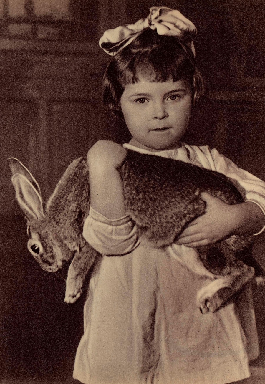 — Этот кролик — не игрушечный, а взаправдашный... Честное пионерское — настоящий! (Снимок сделан в детском саду завода „Красный треугольник“).